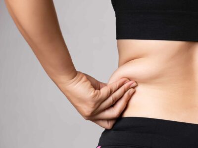 Fat woman hand holding excessive belly fat. Healthcare and woman diet lifestyle concept to reduce belly and shape up healthy stomach muscle.