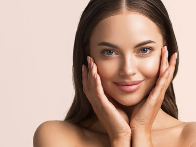 Beautiful woman face close up natural make up hand touchin