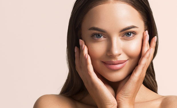Beautiful woman face close up natural make up hand touchin