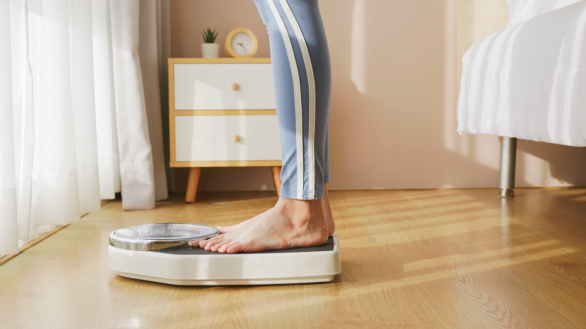 closeup feet of woman measuring weight on scale after exercise