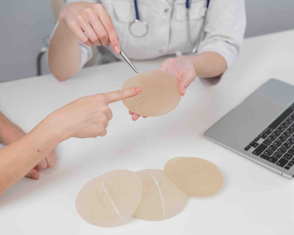 Caucasian woman and plastic surgeon touching and choosing breast implants