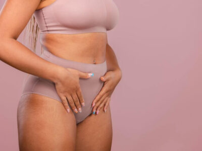 Woman posing in matching underwear on a pink background - Michelle Hardaway M.D.