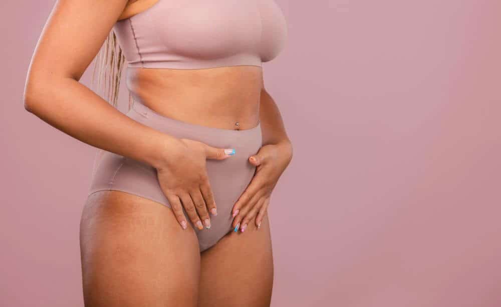 Woman posing in matching underwear on a pink background - Michelle Hardaway M.D.