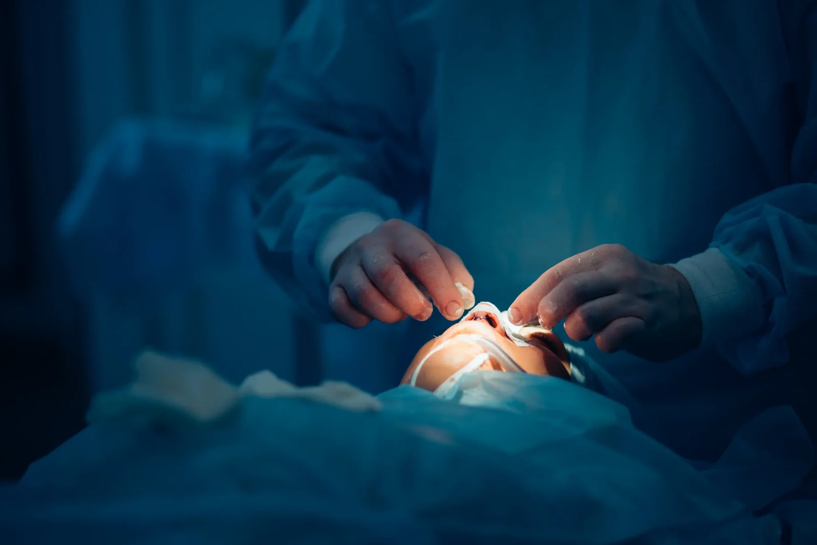 plastic surgeon performing nose job in operating room